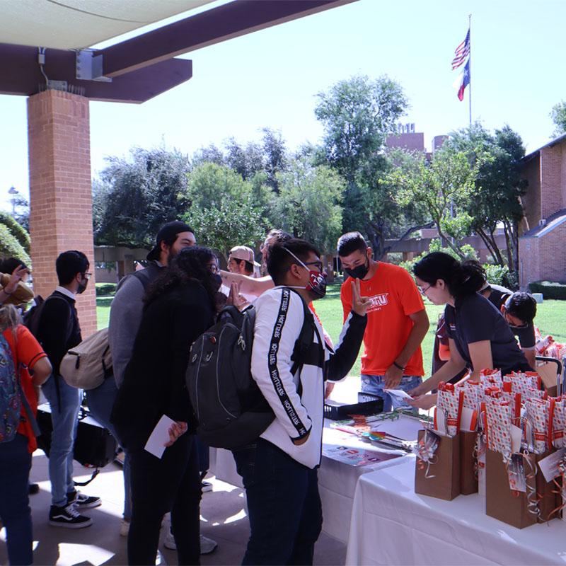 Students surrounding the tables set up by the Office for Sustainability on Campus Sustainability Day on the Edinburg Campus by the Student Union